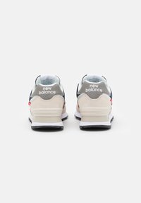 Beige Wildleder- und Mesh-Sneaker mit marineblauen Akzenten. Mit "New Balance"-Branding an der Ferse und Zunge. Weiße Zwischensohle und schwarze Außensohle.