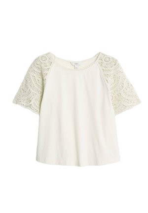 T-shirt à manches courtes en crème avec des accents en dentelle sur les manches. Col rond et coupe décontractée, fabriqué à partir d'un tissu doux.