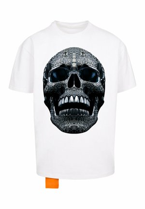 Witte T-shirt met een grote zwarte schedelafbeelding met glanzende accenten, textuurelementen en een koraalkleurig label onderin links.