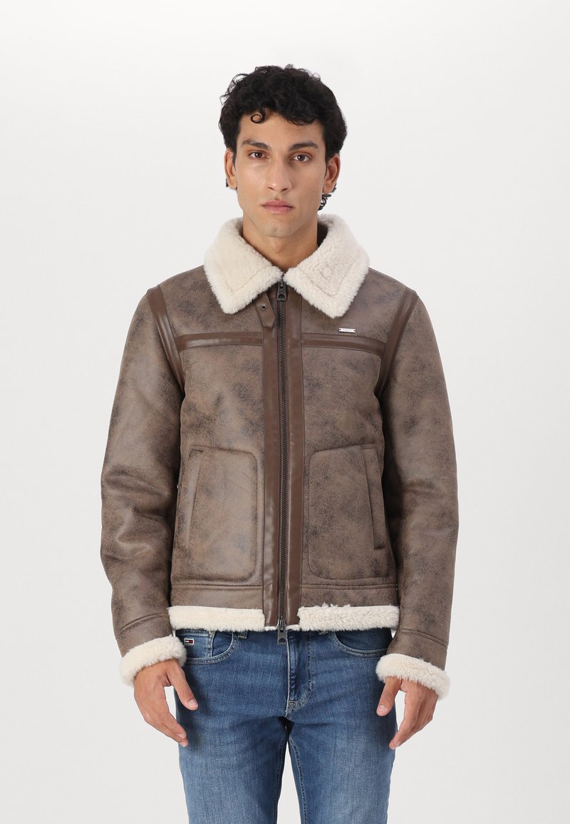 Rudas dirbtinio odos striukė su minkštu baltu avikailio apykakle ir rankogaliais. Turinti užtrauktuką ir dvi priekinės kišenes.