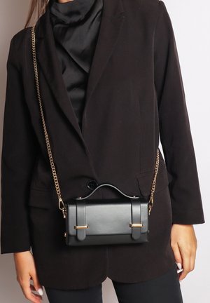 Borsa a mano rettangolare nera con manico superiore e hardware dorato. Caratterizzata da una tracolla a catena e una texture liscia, progettata in uno stile minimalista.