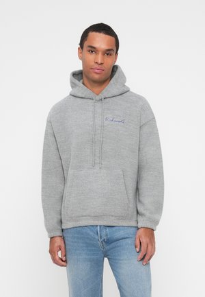 Grå huvtröja i mjukt material med en framficka, dragsko i huvan och en blå broderad logo på bröstet. Lätt avslappnad passform och långa ärmar.
