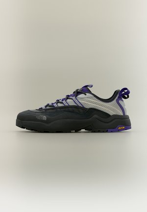 Chaussure de randonnée noire et grise avec des accents violets, tige en mesh, semelle Vibram et logo The North Face sur le côté.