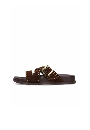 Sandale à enfiler marron avec des clous dorés, une grande boucle dorée et une semelle plate, vue de côté sur fond blanc.