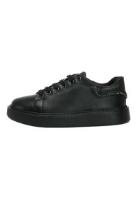 Zapatilla de cuero negra con punta redondeada, diseño de cordones y suela de goma. Presenta una textura suave y acentos de tachuelas plateadas en el talón.