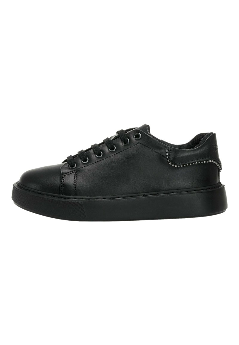Zapatilla de cuero negra con punta redondeada, diseño de cordones y suela de goma. Presenta una textura suave y acentos de tachuelas plateadas en el talón.