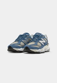 Pair of blue and gray athletic sneakers with white soles and black tread, featuring mesh panels and laces, angled side by side on a white background.
