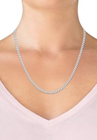 Collana in metallo tono argento con design a catena attorcigliata, che poggia su un collo, accentuando un top a V di colore rosa pallido.