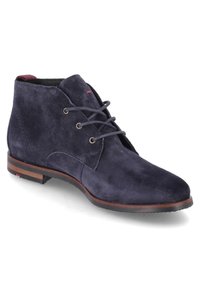 Bottine en daim bleu marine avec laçage à trois œillets, bordure de semelle marron et languette rouge au talon, vue en angle montrant le côté extérieur et l'avant du pied.