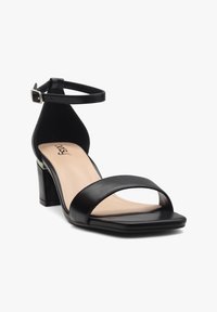 Black leather sandal with square open toe, wide strap across the front, and slim ankle strap with a silver buckle. Square block heel.