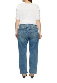 Lichtblauwe denim jeans met een relaxte pasvorm, vijf zakken en zichtbare stiksels. Draag ze met een witte cropped t-shirt en beige hakken.