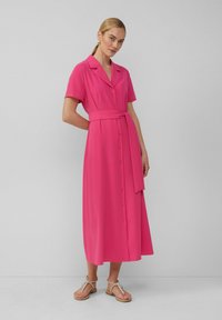 Roze midi-jurk met korte mouwen, rechte kraag, knopen aan de voorkant en een tailleband. Gemaakt van soepele stof en heeft een vloeiende silhouet.