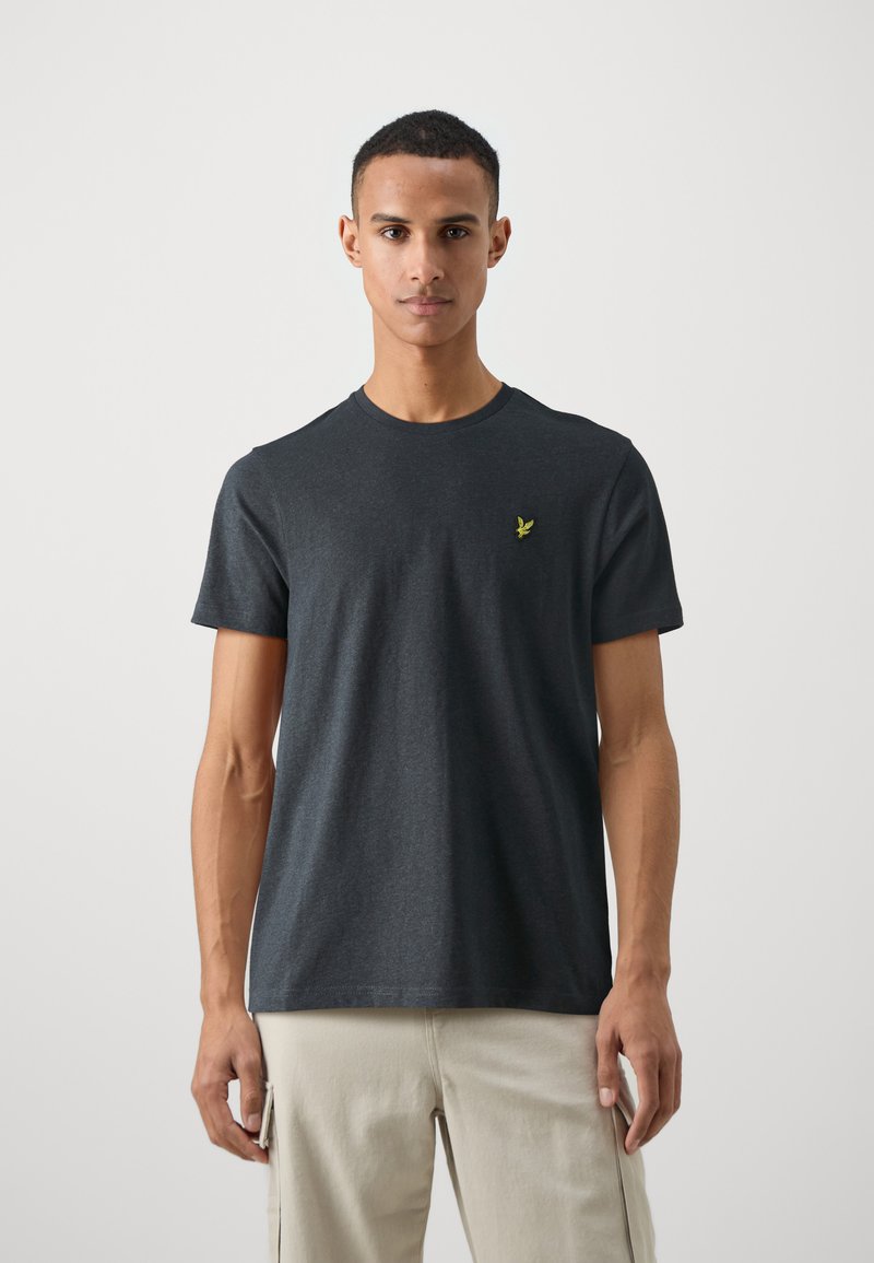 T-shirt en coton gris foncé à manches courtes, col rond et petit logo brodé vert sur la poitrine gauche.