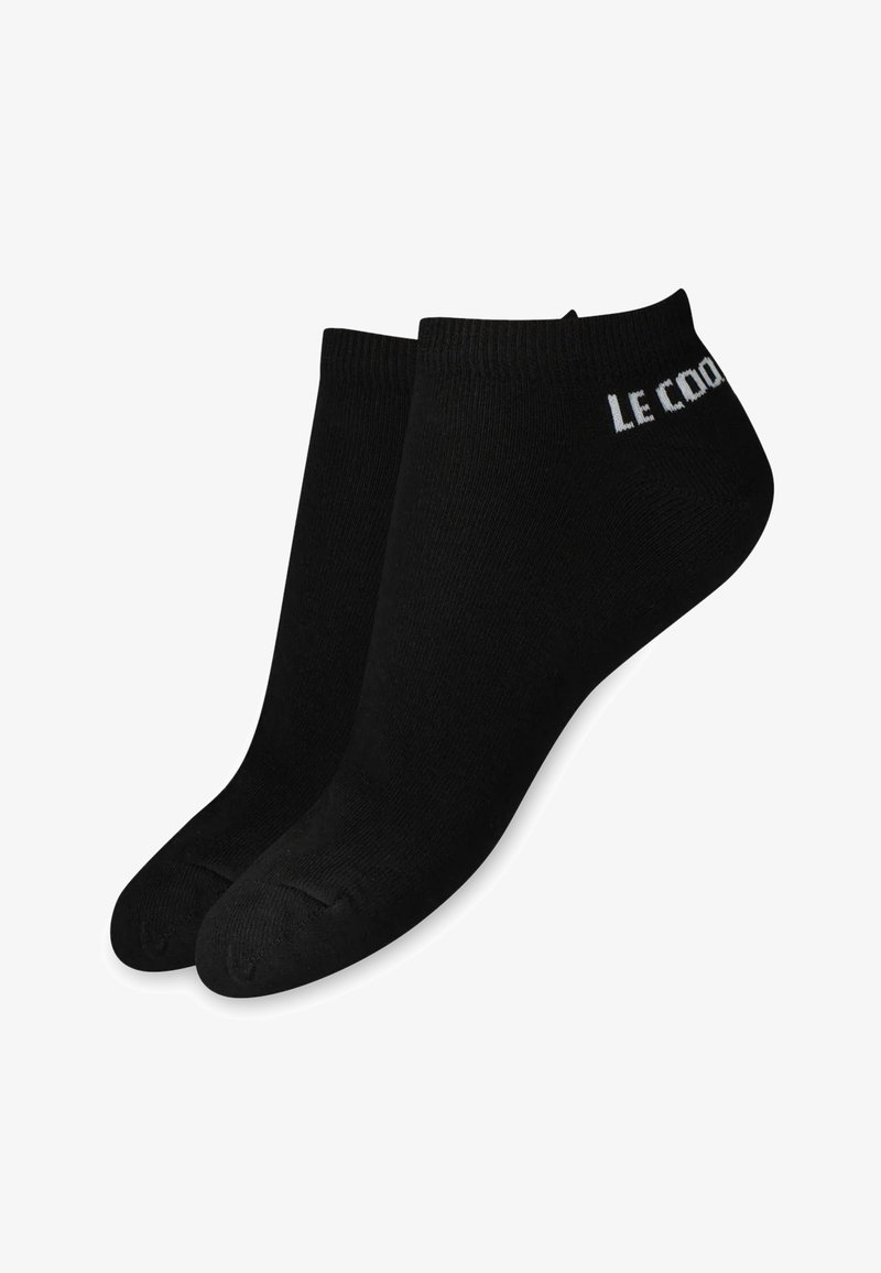 Calcetines negros hasta el tobillo hechos de un tejido suave y elástico. Presenta puños acanalados y texto impreso en blanco en el lateral. Diseño simple y funcional.