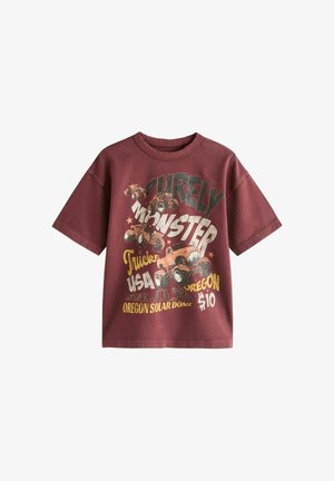 Vinrød kortærmet t-shirt med monster truck-grafik og tekst, der henviser til en USA Oregon truck-begivenhed og billetpris på 10 $.