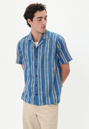 Camisa de manga corta de botón en azul con rayas verticales blancas, hecha de una tela ligera, con cuello tipo camp y botones negros.