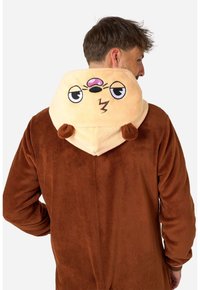 Tuta peluche marrone con cappuccio color crema che presenta un volto di cartone, occhi tondi e simpatiche orecchie. Tessuto morbido, design casual.