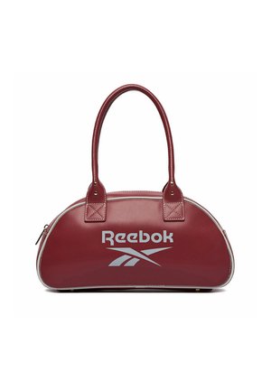 Bolso marrón de Reebok con dos asas redondeadas, logo blanco en la parte delantera y cierre con cremallera en la parte superior, colocado sobre un fondo blanco.