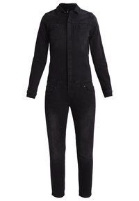 Combinaison en denim noir à manches longues, fermeture boutonnée sur le devant, poches poitrine, jambes fuselées et texture légèrement usée.