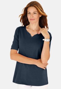 Navyblaues V-Ausschnitt-T-Shirt mit kurzen Ärmeln, das mit einem dekorativen Knopfdetail am Ausschnitt versehen ist. Weicher Stoff mit geradem Schnitt und Seitennähten.