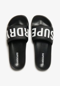 Infradito neri con superficie testurizzata e larga fascia con il testo bianco "SUPERDRY". Suola morbida per il massimo comfort.