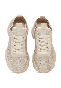 Zapatillas beige con tejido texturizado, acentos brillantes, puntera redonda, cordones planos y una lengüeta en el talón. Suelas de goma.