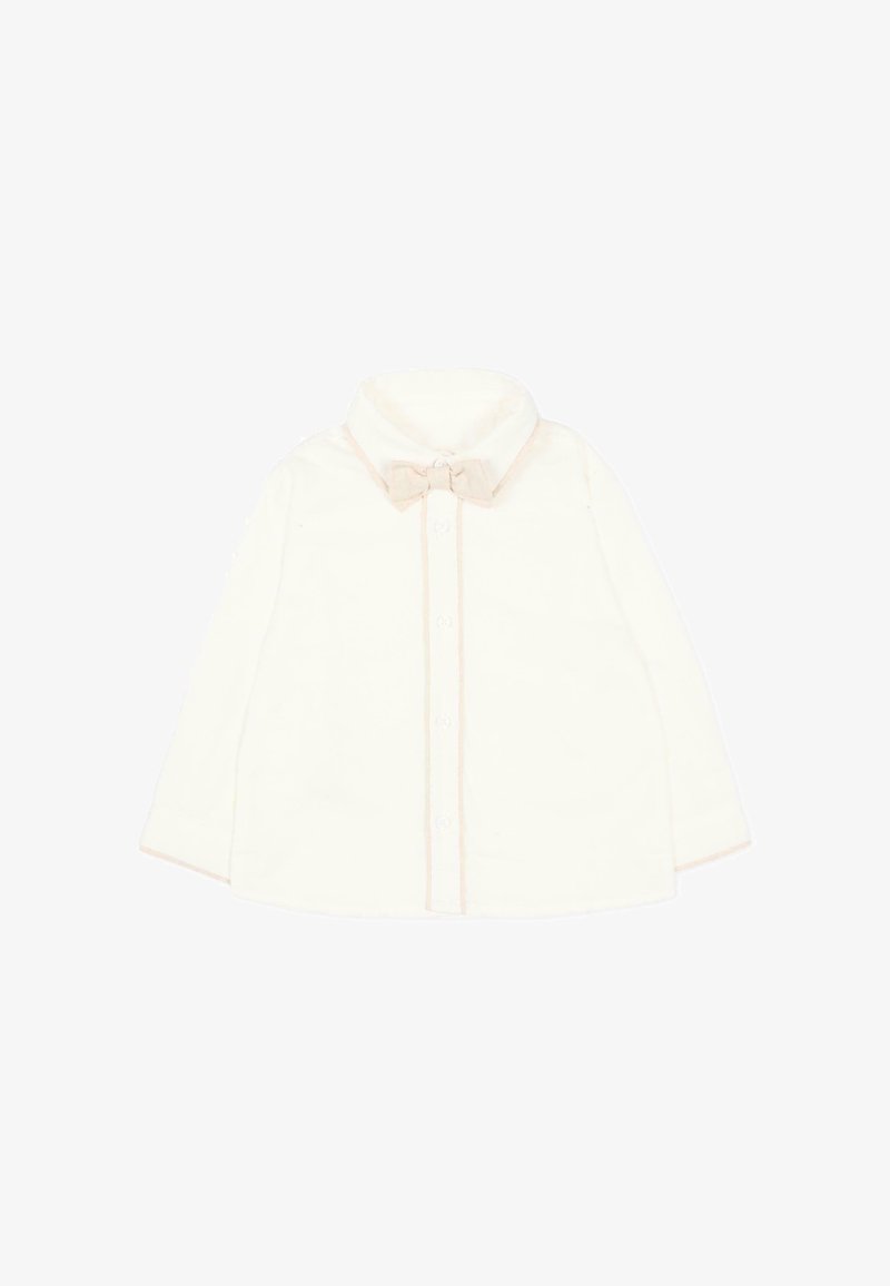 Veste pour bébé à manches longues de couleur crème avec un petit nœud au col et des boutons sur le devant, sur fond blanc.