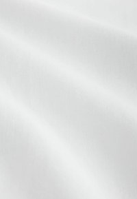 Pehme, sile valge kangas, millel on õrnad voldid ja peenalt nähtav kootud tekstuur pinnal.