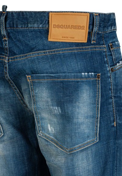 Dunkelblaue Jeans aus Denim mit einem Ledermarkenetikett, sichtbaren Nähten und einer leicht ausgewaschenen Textur im Bereich der Gesäßtasche.