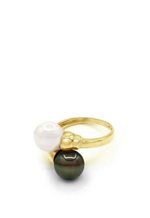 Bague en or ornée d'une perle blanche et d'une perle noire sur un anneau ouvert avec un petit détail en forme de nœud entre les perles.