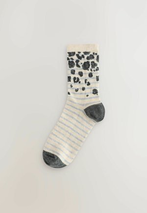 Bavlněné ponožky se strukturovaným šedým a černým leopardím vzorem na krémovém pozadí, s světle modrými pruhy na dolní části a tmavým špičkou.