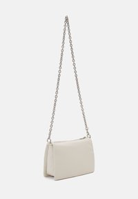 Borsa a mano beige chiaro realizzata in materiale strutturato, con tracolla in catena argentata e chiusura con zip, dalla forma rettangolare e texture liscia.
