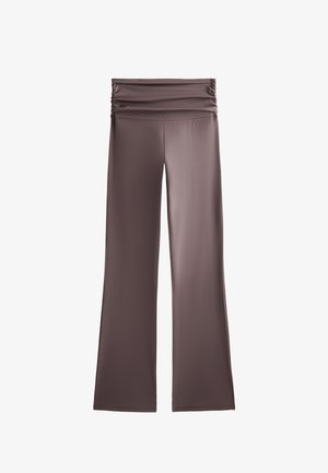 Smeđe, debele hlače od tkanine s širokim, nabranym pojasom. Dizajn s proširenim nogavicama; glatka tekstura, bez uzoraka ili vidljivih metalnih detalja.