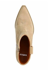 Beige suede ankle boot with a pointed toe, decorative stitching, inner zipper, and a textured finish. Lined with brown material inside.