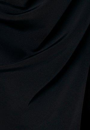 Sile must kangas pehmete voltidega ja drapeeringutega, mis loovad õrnu varje ja tekstuuri.