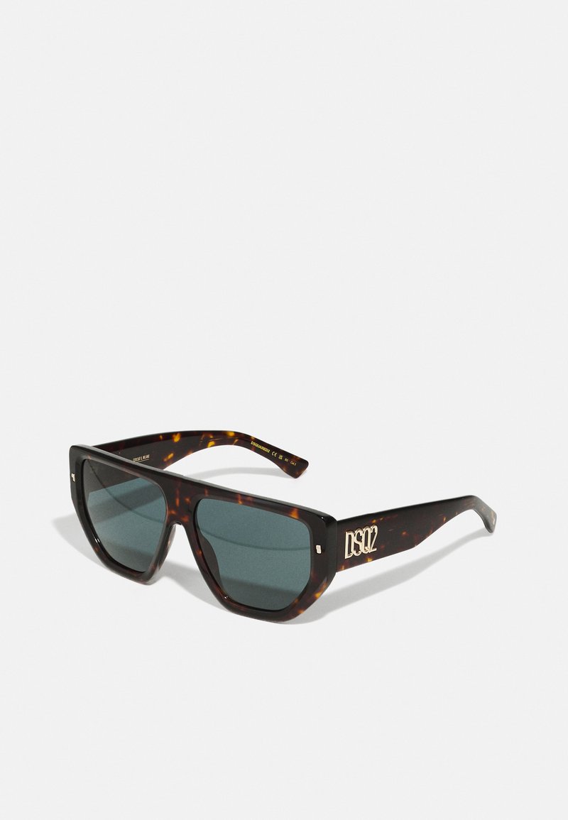 Óculos de sol em padrão tartaruga com armação quadrada, lentes escuras, logotipo dourado na haste e detalhes metálicos decorativos na parte frontal.
