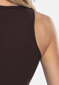 Bordowy prążkowany top na ramiączkach z okrągłym dekoltem i szerokimi ramiączkami, wykonany z miękkiego, elastycznego materiału. Gładka faktura z precyzyjnym szwem.