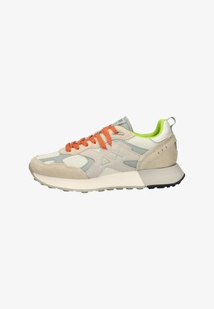 Zapatillas beige y gris que combinan materiales de textil y ante, con cordones naranjas, acentos verdes y una suela blanca gruesa con una suela exterior negra.