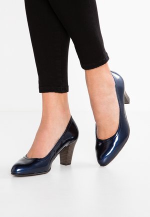 Granatowe buty na wysokim obcasie wykonane ze skóry lakierowanej, z zaokrąglonym noskiem, teksturowaną powierzchnią i masywnym, piętrowym obcasem.