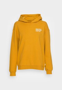 Sudadera amarilla mostaza con capucha, con un pequeño logo blanco en el pecho. Fabricada con tejido suave y cuenta con puños y bajo acanalados.