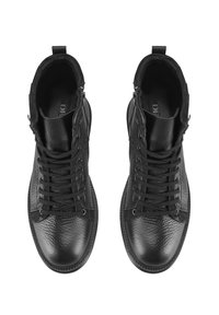 Bottes montantes en cuir noir avec une finition texturée, dotées de lacets à l'avant, de zips sur le côté et d'un design à bout rond. Accents lisses sur la semelle.