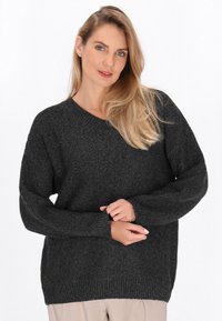 Ciemnoszary sweter z dzianiny z dekoltem w serek i długimi rękawami, posiadający strukturalny wzór oraz prążkowane mankiety i dół.