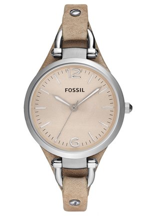 Montre-bracelet ronde Fossil avec cadran beige, boîtier argenté, index horaires minimalistes et bracelet en cuir marron clair avec rivets métalliques.