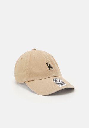 Casquette de baseball beige avec un logo noir de LA, en coton, visière incurvée, design à six panneaux et sangle ajustable à l'arrière.
