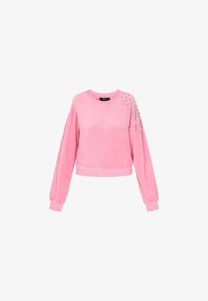 Rozā samta džemperis ar apkakli, garām piedurknēm un ribotām aprocēm. Tiek piedāvāti sudraba rotājumi uz kreisās pleca.