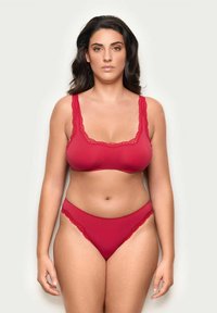 Röd bralette med spetskant och matchande bikini-set i mjukt material, med rundad halsringning och breda axelband för stöd.