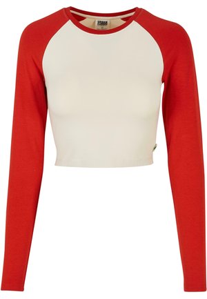 Rød langermet crop top med hvit kropp; har raglanermer og rund hals. Laget av mykt, elastisk materiale.