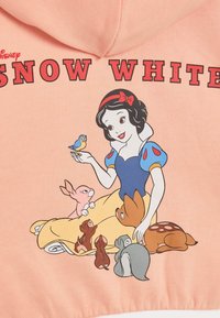Haut à capuche rose avec une illustration de Blanche-Neige, portant une robe bleue, entourée de divers animaux, avec le texte "BLANCHE-NEIGE" au-dessus.