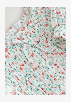 Blommig klänning med vit bakgrund och rosa blommor samt gröna blad. Tyget har en rynkad textur och en knytaccent.