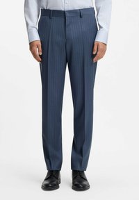 Granatowe spodnie garniturowe z delikatnymi pionowymi prążkami, dopasowany krój i gładka faktura tkaniny; w połączeniu z czarnymi butami garniturowymi.